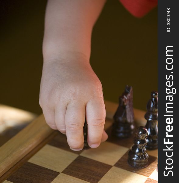 Young child playing chess on traditional wood chess set