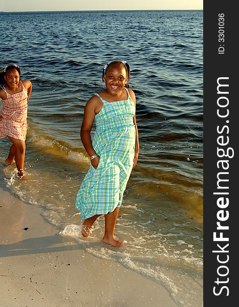 Two african american sisters walking along shoreline. Two african american sisters walking along shoreline