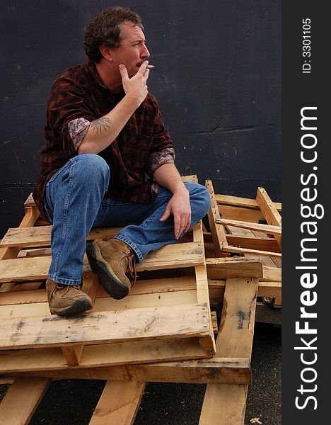 Smoking man on wood pallets