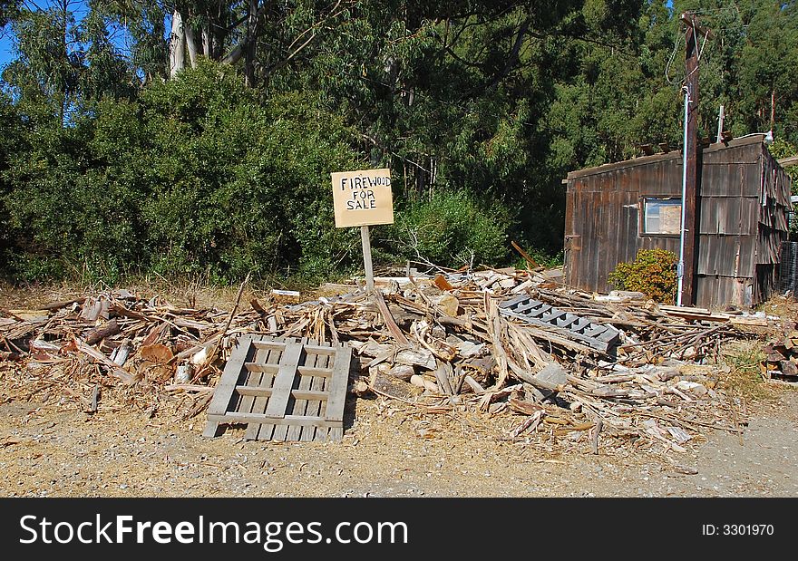 Pile of junk wood with a sign Firewood for Sale.