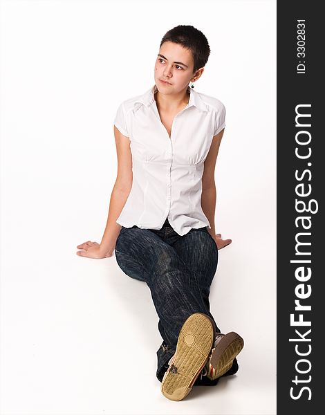 Close-cut brunette sits on the floor on white background