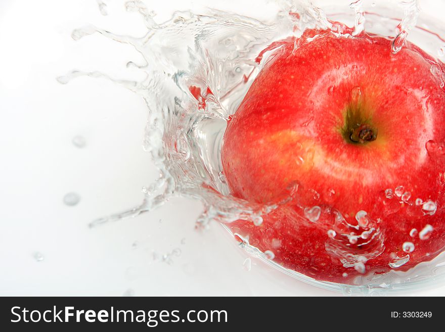 Delicious fresh apple with water splash over white.