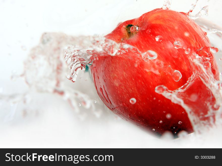 Delicious fresh apple with water splash over white.