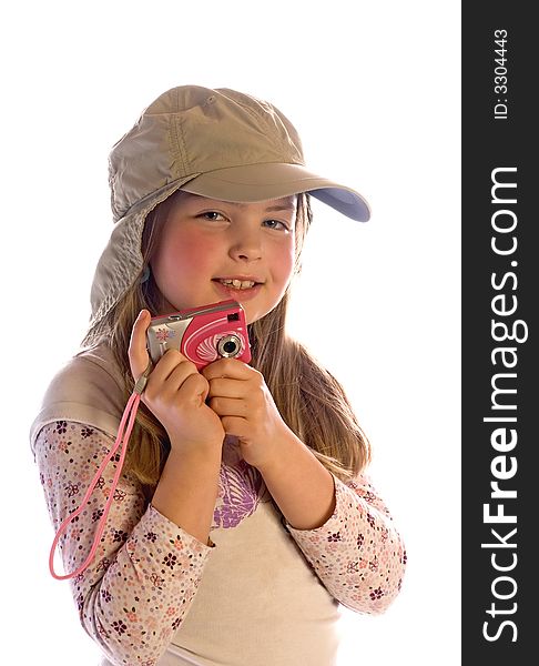 A cute young girl smiles while wearing a cap and holding a camera. Isolated against a white background. A cute young girl smiles while wearing a cap and holding a camera. Isolated against a white background.