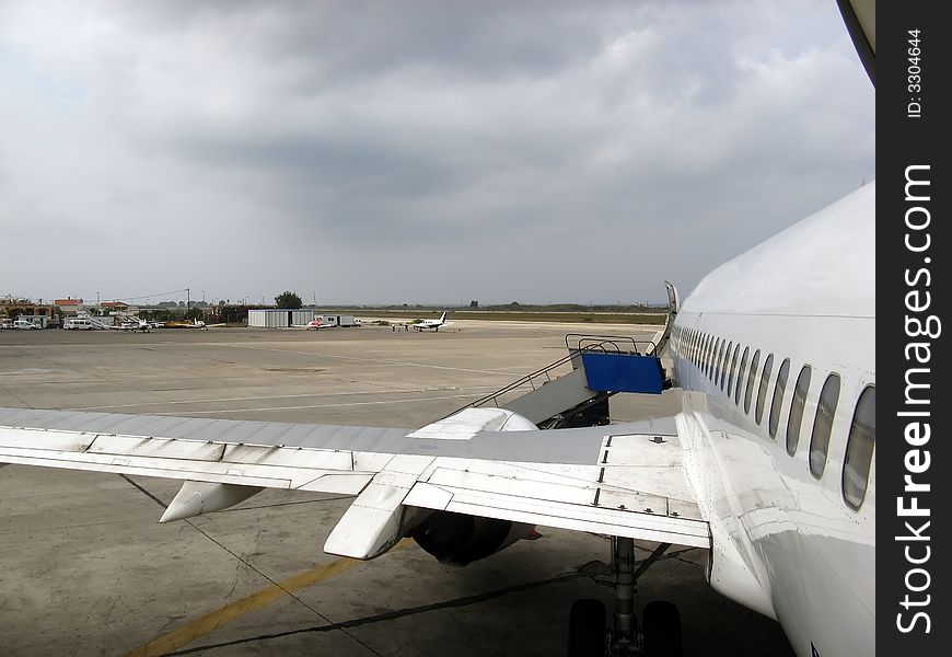 An aircraft side view from rear on a cloudy morning at the airport