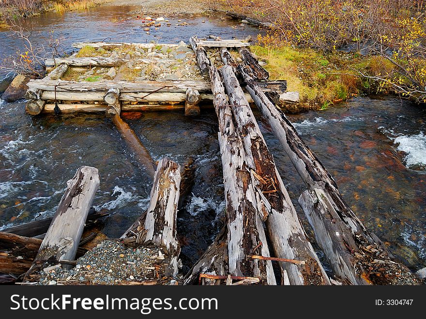 The old destroyed bridge through the river