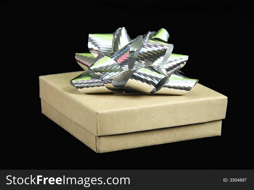 Gift box with silver bow on top with black background
