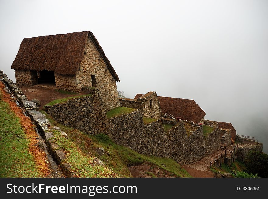 Machu Picchu guardhouse with fog lifting behind