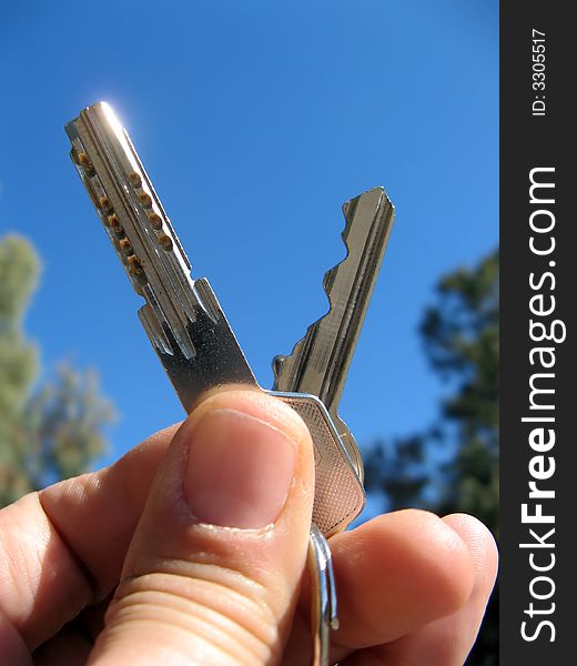 Keys in hand with blue sky background