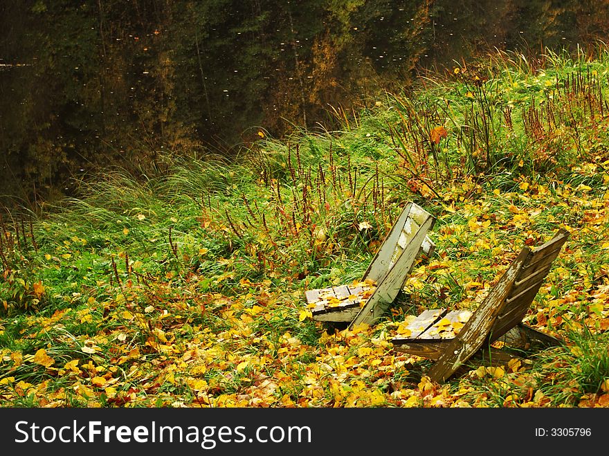 Two wooden chairs by river