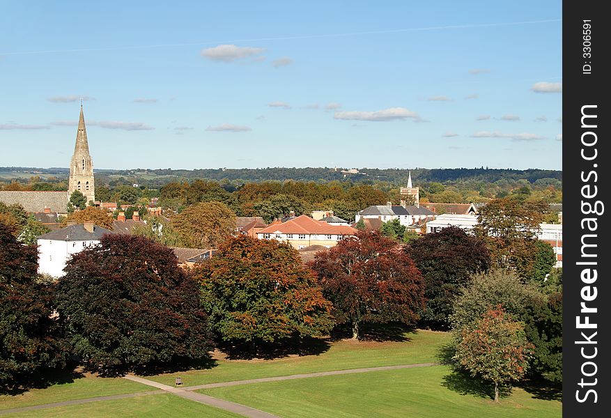 Early Autumn Colours over a Town and Park in England, with Church Spire in the distance. Early Autumn Colours over a Town and Park in England, with Church Spire in the distance