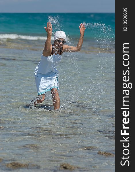 Woman being sprinkled at the seaside