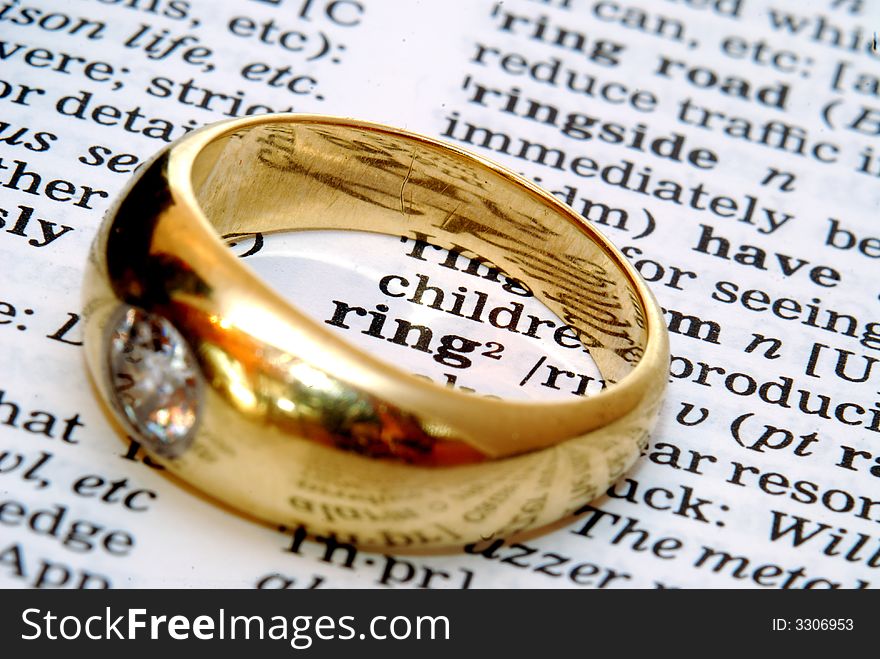 The word ring out of a dictionary with a gold ring next to it. The word ring out of a dictionary with a gold ring next to it