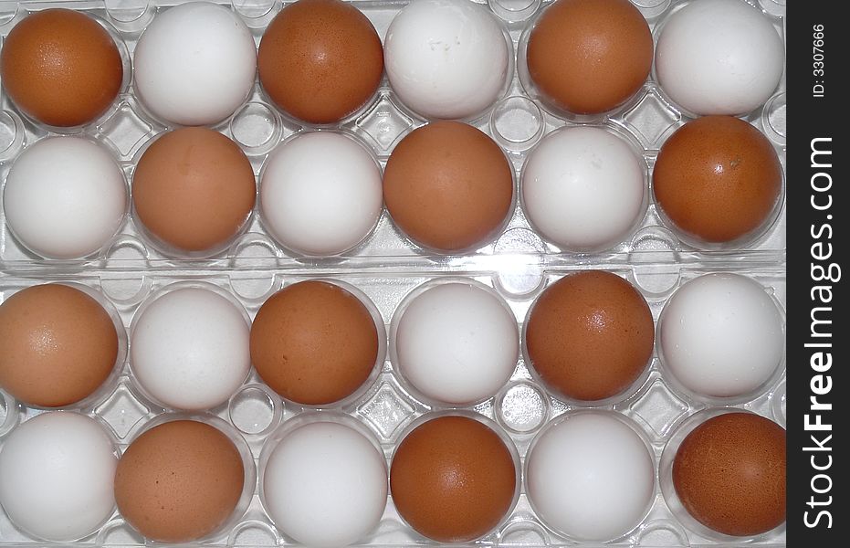 Brown and white eggs dot clear plastic egg carton. Brown and white eggs dot clear plastic egg carton.