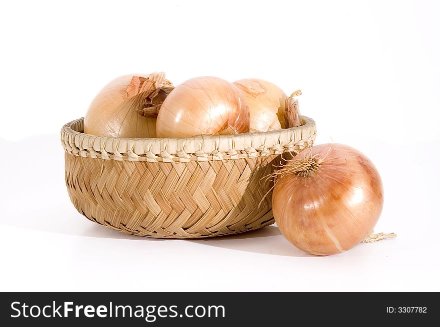 Group of onions on a basket isolated over white