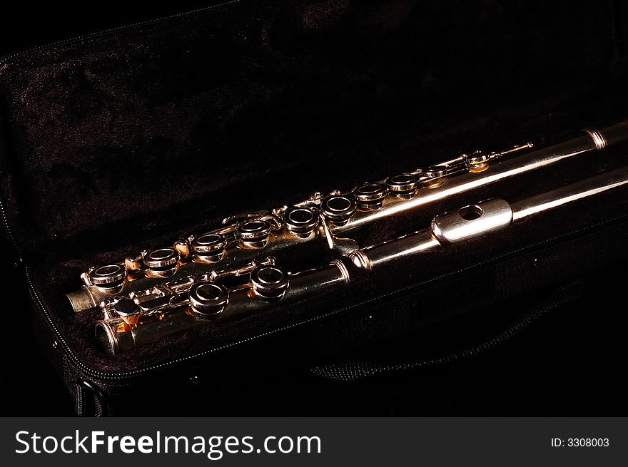 A closed hole Take-down flute in case, black background