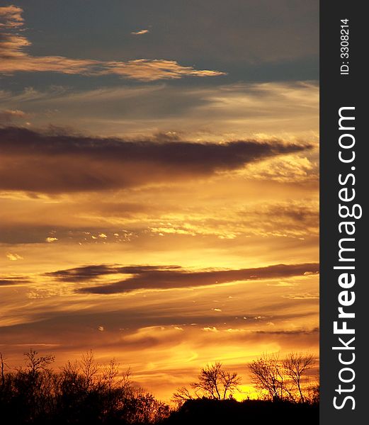 An orange sunset casting over a blue sky. An orange sunset casting over a blue sky.