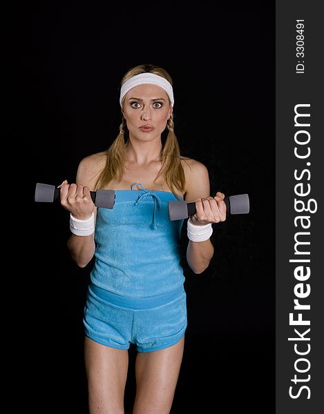 Woman execising with weights against a black background