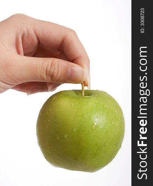 Holding a fresh green apple over a white background. Holding a fresh green apple over a white background