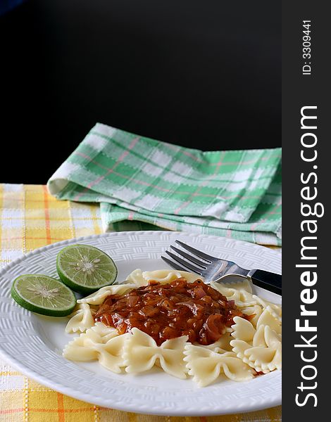 A plate of bow tie pasta with zesty onion and spice gravy