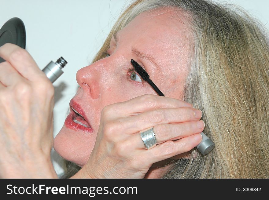 Woman applying makeup at home.