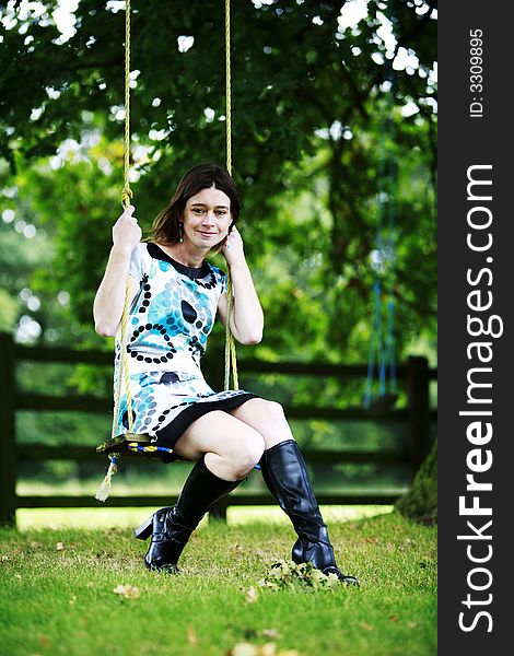 Young woman playing on a swing. Young woman playing on a swing