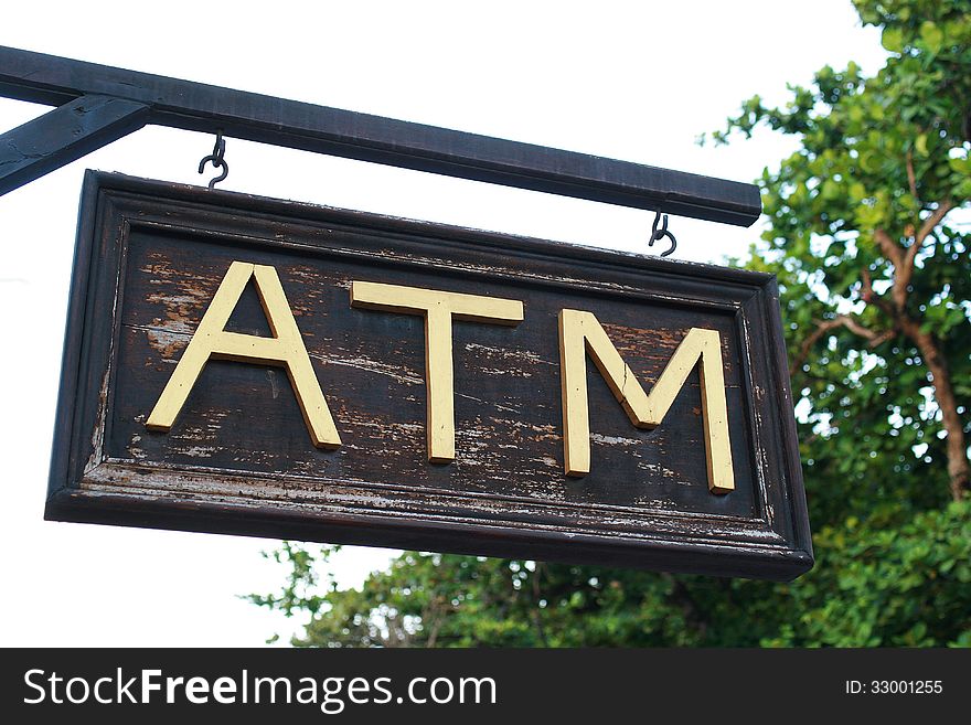 The wood atm sing with gold letter