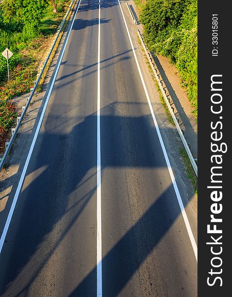 Shadow on an empty road early in the morning. view from the top. Shadow on an empty road early in the morning. view from the top