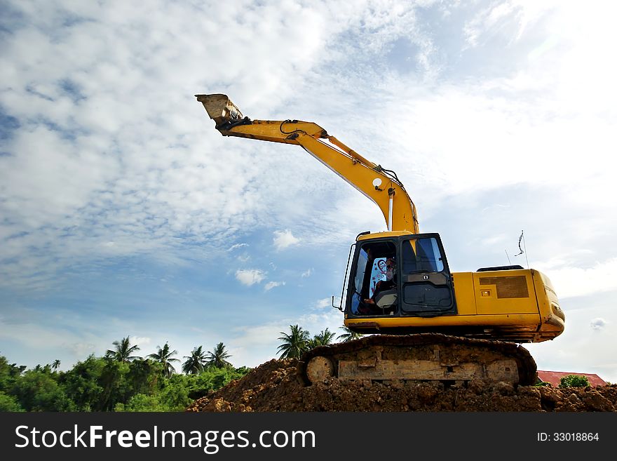 Excavator and backhoe on sky background