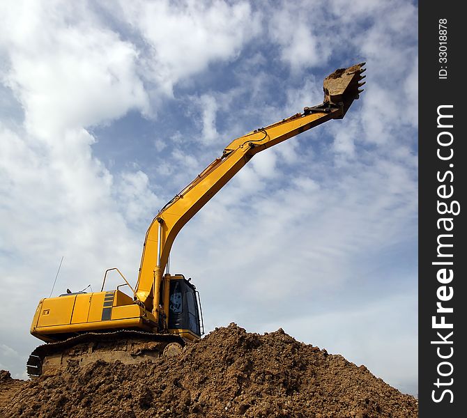 Excavator and backhoe on sky background