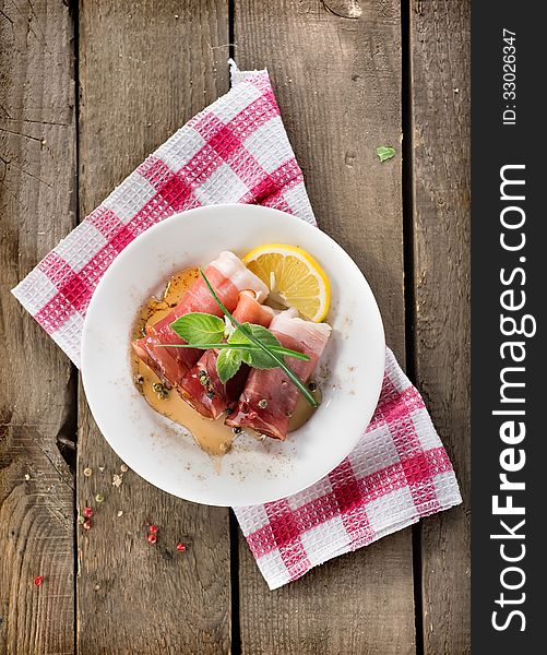 Bacon in plate on a wooden background