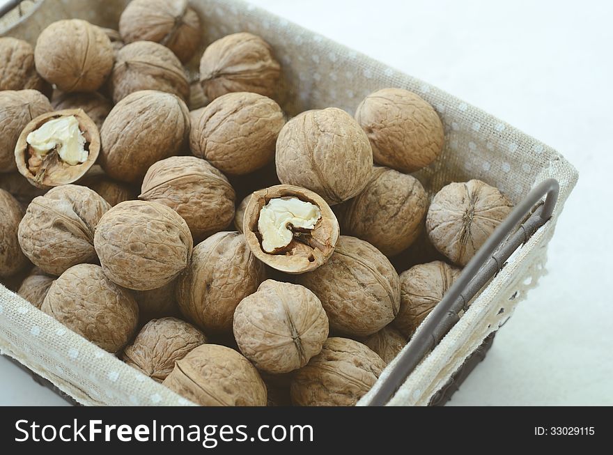 Whole walnut in wire basket in French style on light background