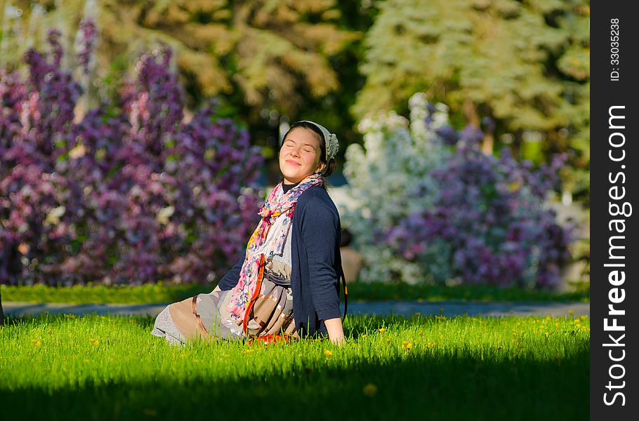 Happy young female relaxing outdoor on the green grass. Happy young female relaxing outdoor on the green grass