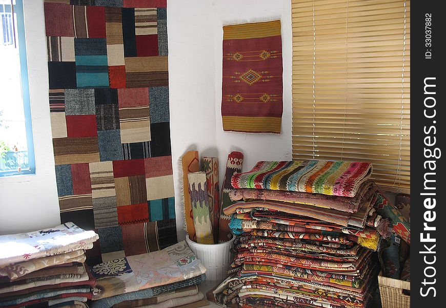 Old self-made carpets and bedspreads in a junk shop. Old self-made carpets and bedspreads in a junk shop