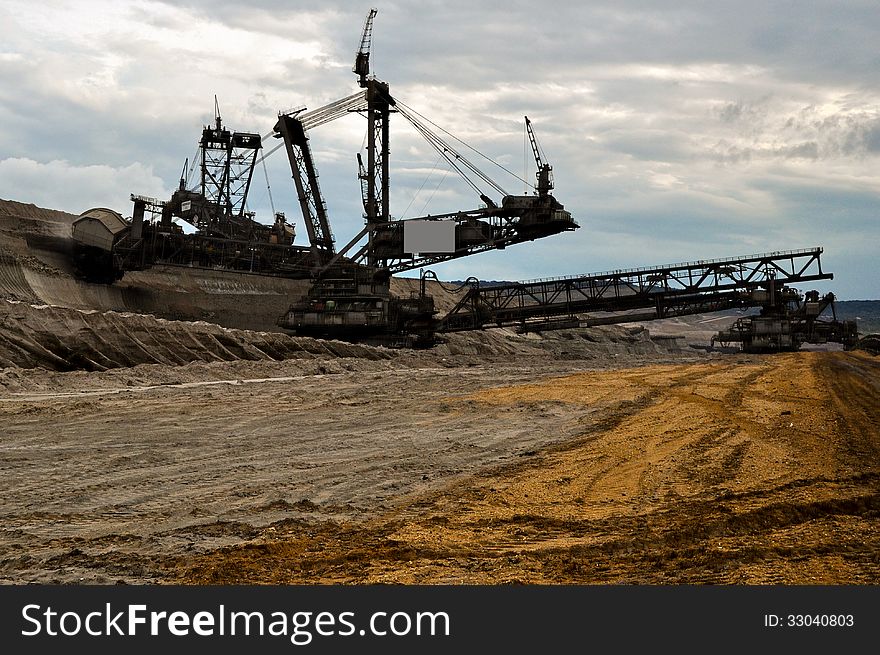 Enormous excavator at work in open coast coal mine. Enormous excavator at work in open coast coal mine