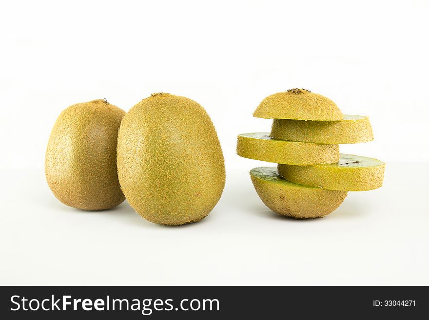 Whole kiwi fruit and his sliced segments isolated on white background, include soft shadow