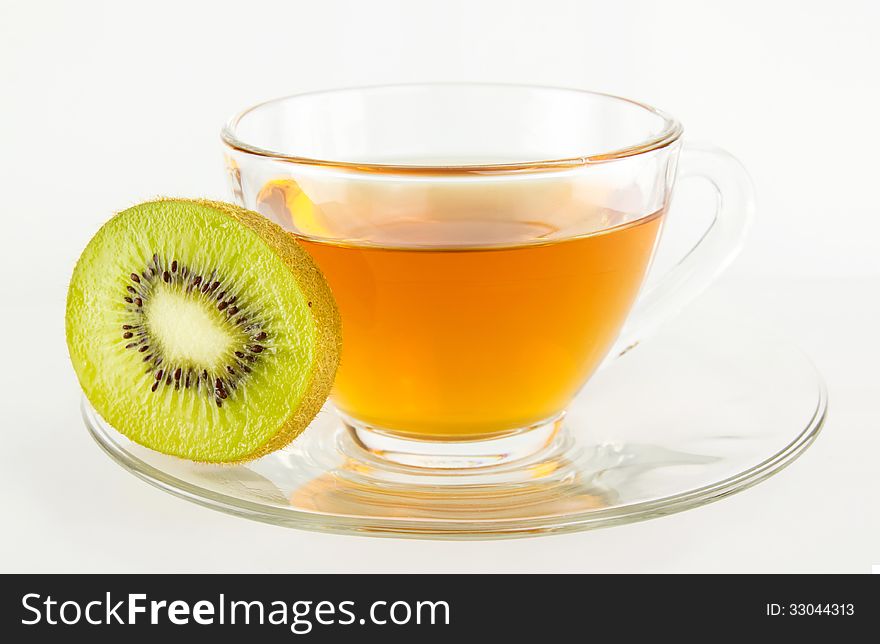 Tea in cup and piece of kiwi fruit isolated on white background. Tea in cup and piece of kiwi fruit isolated on white background