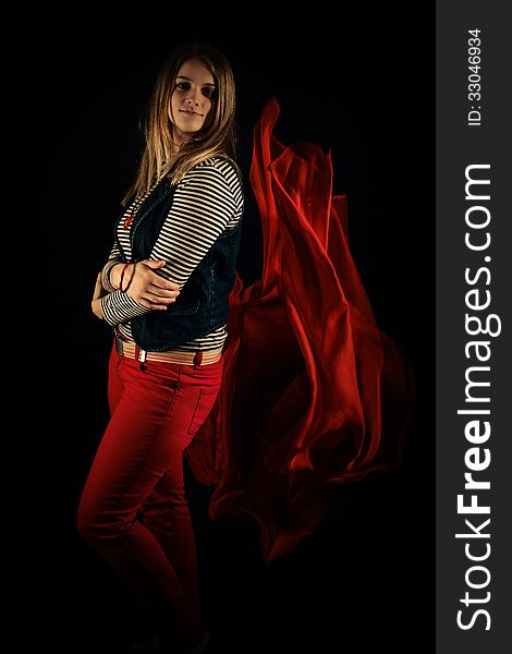 Beautiful Girl Against Red Fabric In The Dark