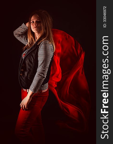 Beautiful girl against red fabric in the dark