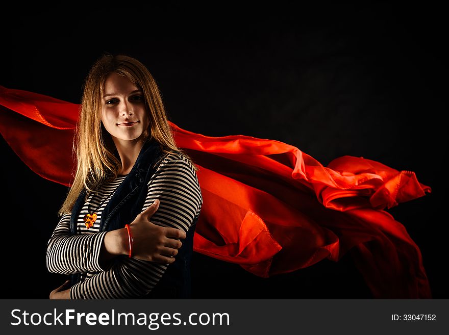 Beautiful girl against red fabric in the dark