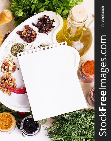 Blank notebook sheet with spices and herbs on the wooden board