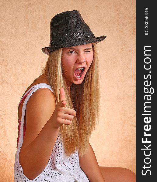 Teenage Female With Black Hat Winking And Pointing. Teenage Female With Black Hat Winking And Pointing