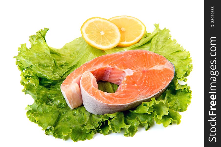 Salmon steak ready to cook at lettuce leaf isolated over white