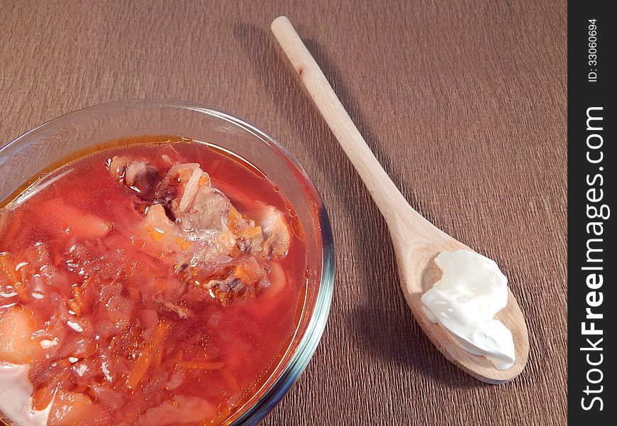 Red soup with chicken and sour cream, wooden spoon. Red soup with chicken and sour cream, wooden spoon