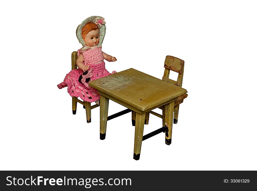 Vintage doll sitting at the table isolated on white background. Vintage doll sitting at the table isolated on white background