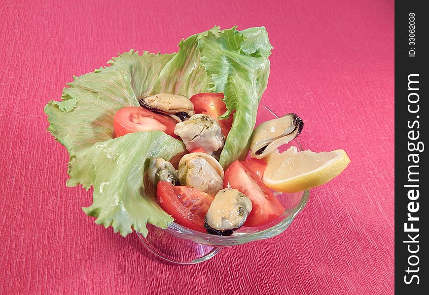 Salad with tomatoes and mussels in lettuce leaves, lemon
