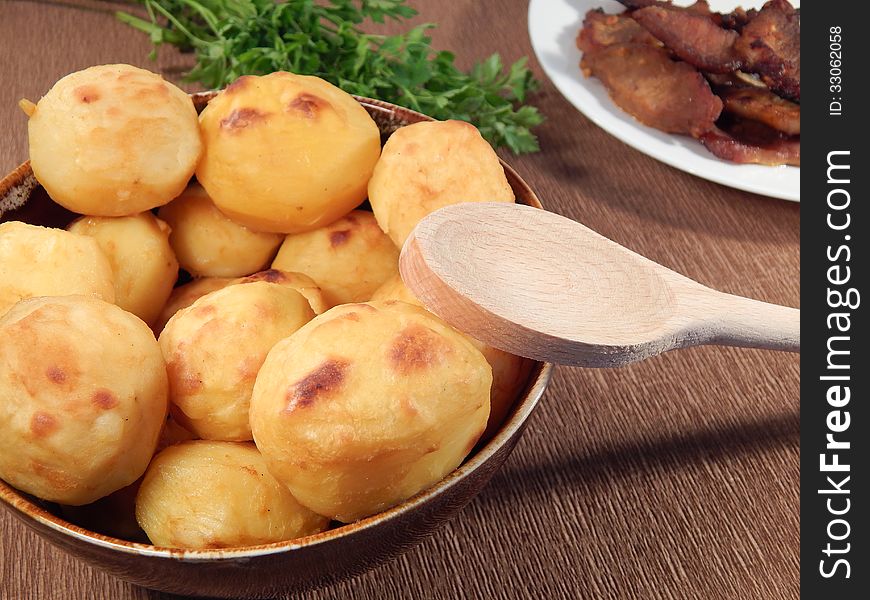 Baked potatoes in a clay pot and roast pork
