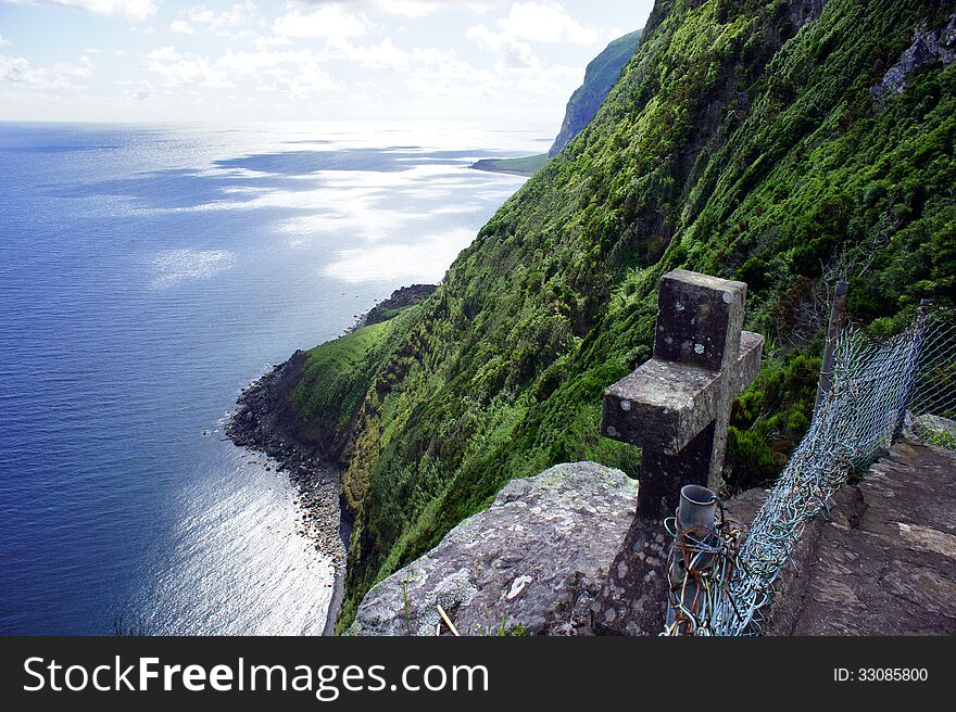 Wild coast and ancient stone cross