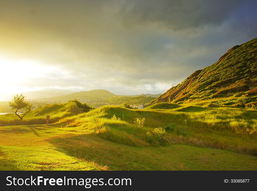 Sunset On Green Grass Hills