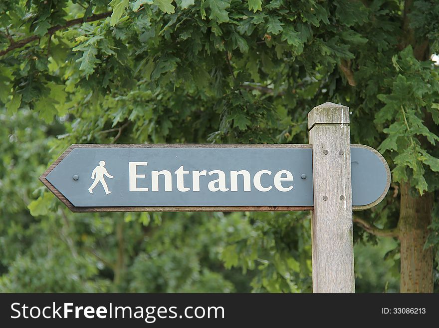 A Sign Post Pointing to a Pedestrian Entrance. A Sign Post Pointing to a Pedestrian Entrance.